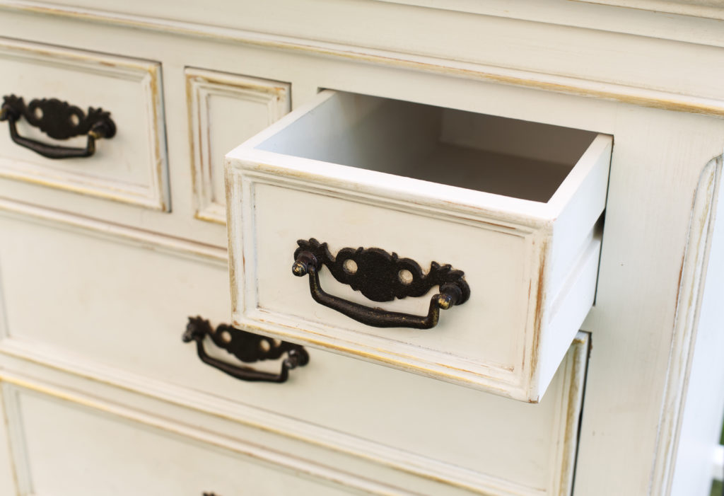 Vintage wooden chest of drawers with black metal handles open